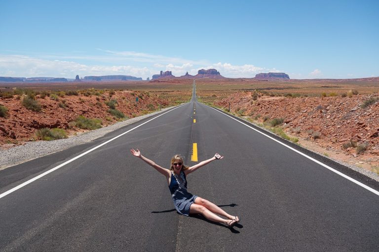 Girl sitting on road at Forrest Gump Point Monument VAlley