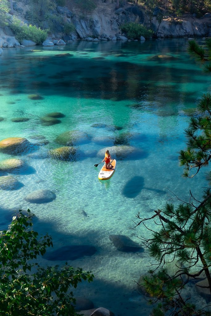 Girl paddle boarding in Secret Cove in Lake Tahoe