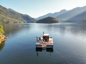 group waveing at camera from Tofino's Floating sauna
